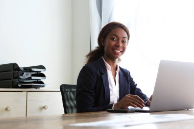 Laptop ile masa başında oturan kendine güvenen Afrika işkadını portresi