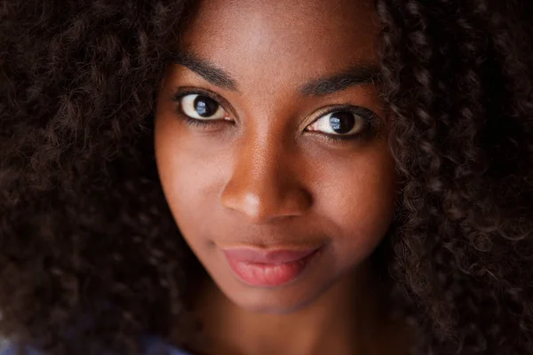 巻き毛を持つ魅力的な若いアフリカ女性の肖像画を間近します — ストック写真