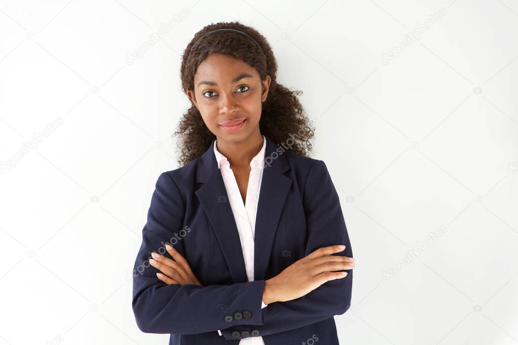 Portrait of attractive young african businesswoman standing against white background with arms crossed