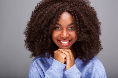 Kıvırcık saçlı gülümseyen genç Afro-Amerikan kadın portresi kapatın