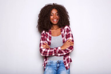 Kollarını beyaz arka plan üzerinde çarpı işareti ile duran şık genç Afro-Amerikan kadın portresi