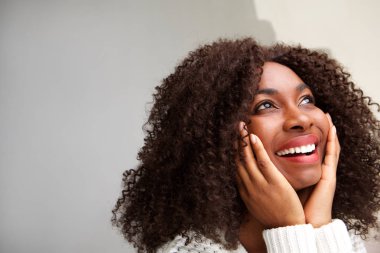 Uzak elleriyle yüzünü arıyor kıvırcık saçlı güzel genç Afrikalı kadın portresi kapatın