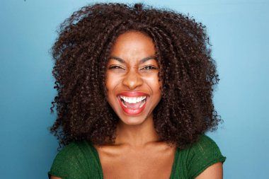 Heyecanlı genç Afrikalı kadın üzerinde mavi arka plan açık ağız ile gülüyor kapatın