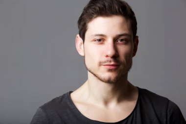 Yatay gri bir arka plana dayanır yakışıklı genç adam portresi kapatın