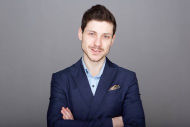 Gri arka planı gülümseyen genç işadamı portresi
