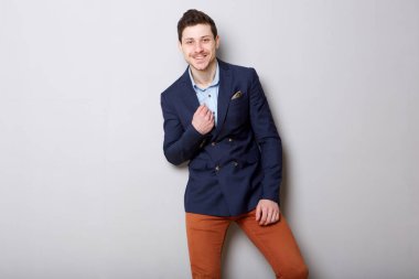 Gri arka planı gülümseyen yakışıklı genç işadamı portresi