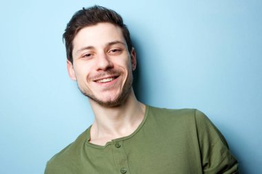 Yatay mavi arka planı gülümseyen genç adam portresi kapatın