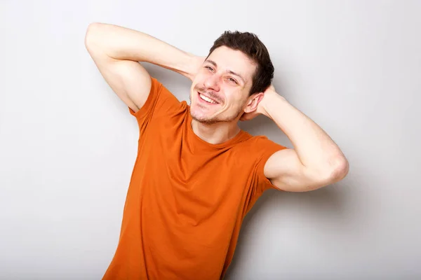 Retrato Jovem Feliz Sorrindo Com Mãos Atrás Cabeça Contra Fundo — Fotografia de Stock