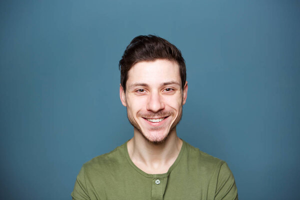 Close up horizontal portrait of attractive young man against blue background