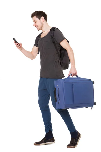 バッグ携帯電話を見ていると若い男性旅行者の完全な長さの肖像画 — ストック写真