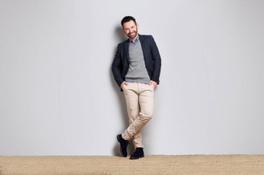 Gri duvara yaslanmış cool işadamı portresi