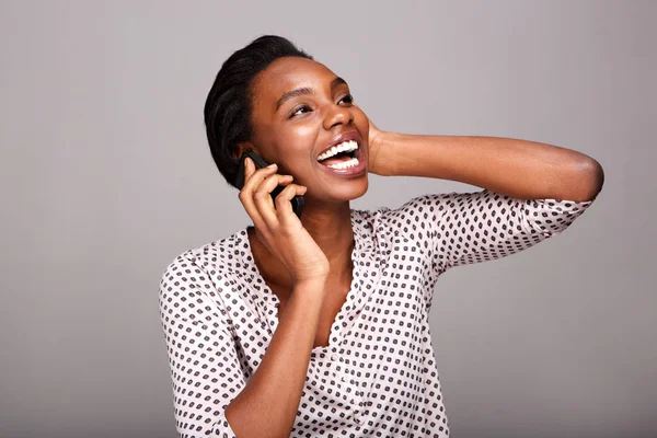 Side portrait of beautiful woman talking on mobile phone and laughing