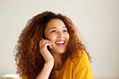 Karınca cep telefonu üzerinde konuşurken gülümseyen çekici genç karışık ırk kadın portresi kapatın