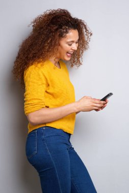 Cep telefonu görünümlü ve gülen genç kadın portresi yan