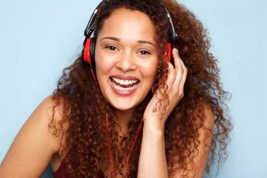 Tarafından mavi arka plan kulaklık ile müzik dinlemek mutlu genç kadın portresi