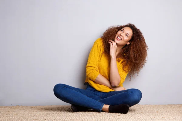 見上げると笑って床に座って陽気な若い女性の肖像画 — ストック写真