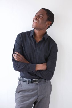 Portrait of happy african businessman standing against white background with arms crossed