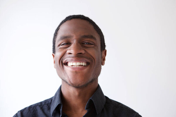 Close up horizontal portrait of young african american man smiling against white background