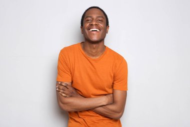 Beyaz arka plan üzerinde çarpı işareti silah ile gülen mutlu siyah adam portresi