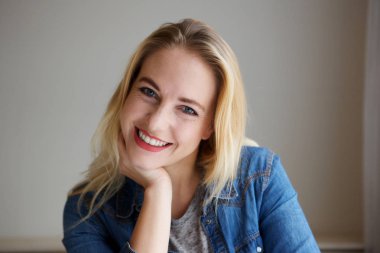 Yandan eğilerek mutlu genç sarışın bir kadın portresi kapatın