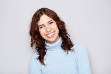 Gülümseyen gri arka plan karşı genç kadın portresi kapatın