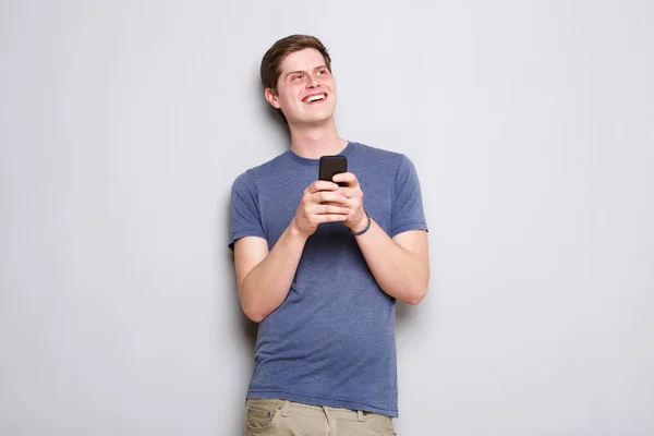 Retrato Del Joven Sonriendo Sosteniendo Teléfono Celular Por Pared Gris — Foto de Stock