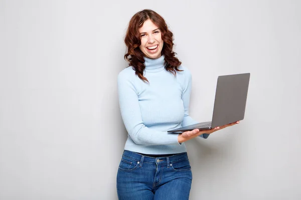 Portret Van Jonge Vrouw Lachen Laptopcomputer Houden Tegen Grijze Achtergrond — Stockfoto