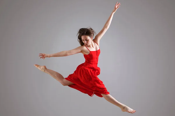 Portret Van Elegante Danser Rode Jurk Springen Tegen Grijze Achtergrond — Stockfoto