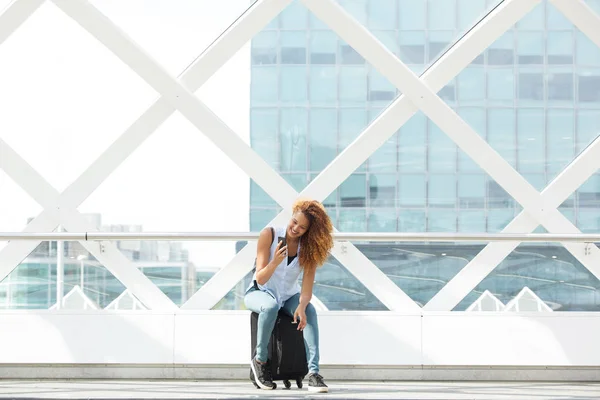 Portrait Happy Woman Sit Suitcase Station Platform Looking Mobile Phone — Stok Foto