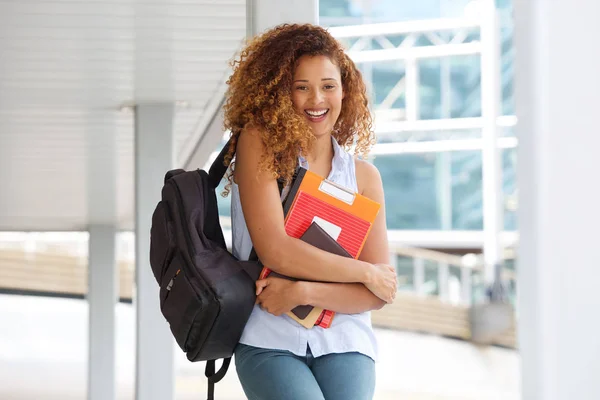 本とバッグ キャンパスで笑いながら幸せな女子学生の肖像画 — ストック写真