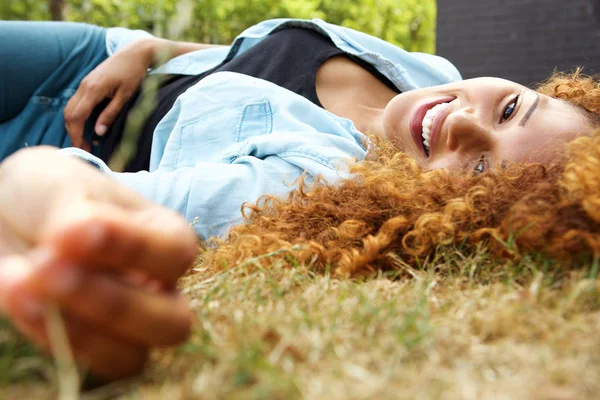 外の芝生の上に横たわる魅力的な若い女性の肖像画 — ストック写真