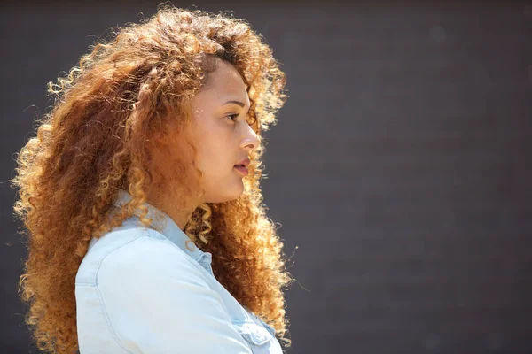 Porträt Einer Jungen Frau Mit Lockigem Haar Gegen Graue Wand — Stockfoto