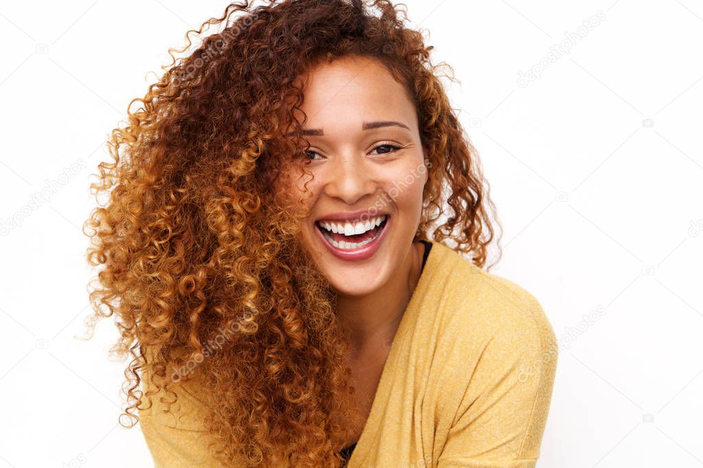 Close up portrait of happy young woman with curly hair laughing against white background