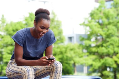 Cep telefonu açık havada arayan mutlu genç kadın portresi