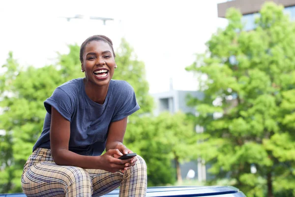 Portret Van Jonge African American Vrouw Lachen Met Cellphone Outdoors — Stockfoto