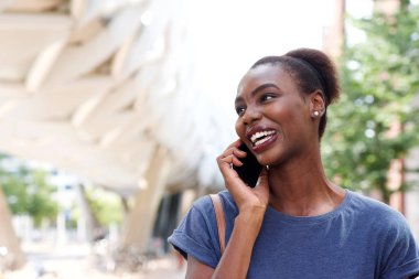Şehrin cep telefonu konuşurken gülümseyen genç Afrikalı kadın portresi kapatın 