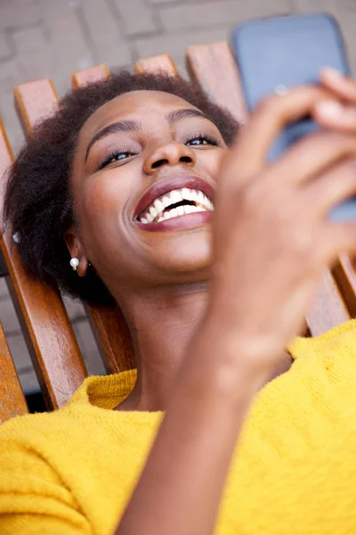 Portrét Šťastný Afroamerické Ženy Sedí Venku Při Pohledu Mobilní Telefon — Stock fotografie