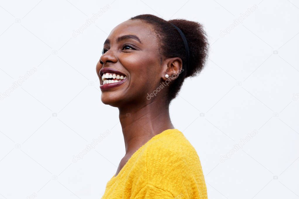 Close up side portrait of happy young african american woman laughing against isolated white background