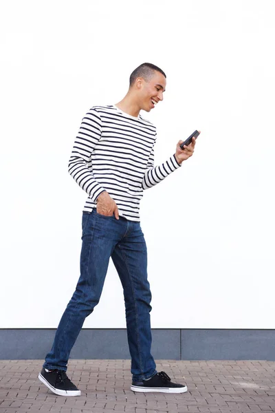Портрет Молодого Человека Идущего Белой Стене Смотрящего Мобильный Телефон — стоковое фото