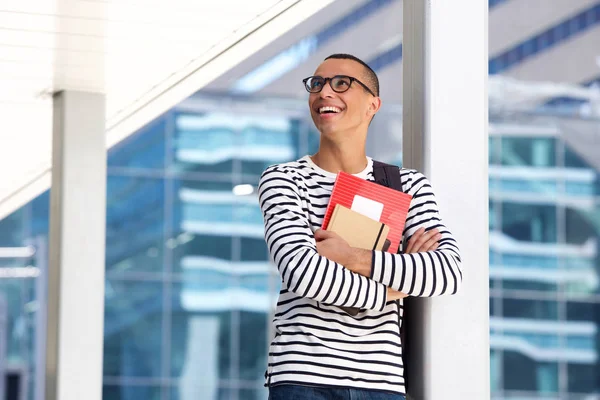 有眼镜和书站在校园里的快乐男大学生的肖像 — 图库照片