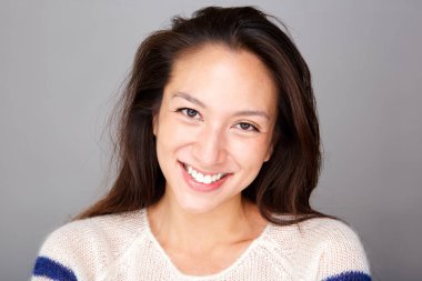 Ön yüz gri bir arka plana dayanır gülümseyen Genç Asyalı kadın portresi kapatın