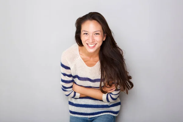 笑顔若いアジア女性が腕を組んで灰色の壁によってポーズの水平の肖像 — ストック写真