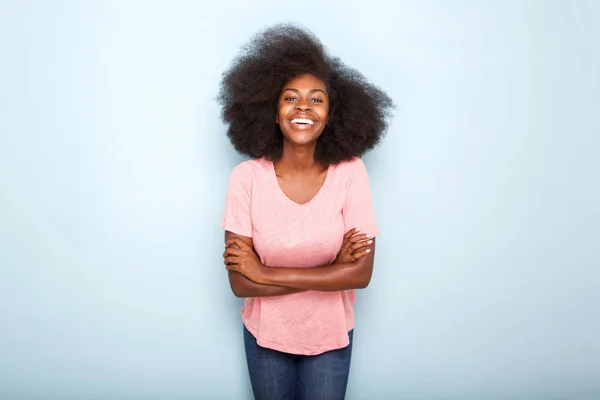 有吸引力的年轻黑人妇女的画像微笑与胳膊横渡在被隔绝的蓝色背景 — 图库照片