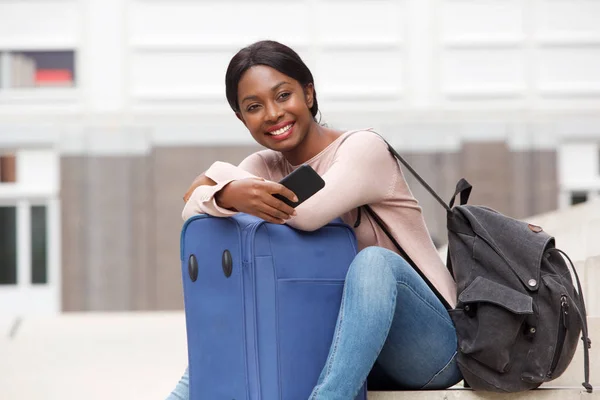 Retrato Mujer Negra Joven Feliz Sentada Afuera Con Maleta Teléfono — Foto de Stock