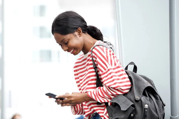 Retrato Lateral Jovem Afro Americana Olhando Para Telefone Inteligente Sorrindo — Fotografia de Stock