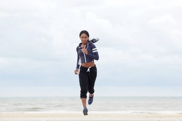 在海滩上奔跑的运动的非洲美国妇女的全身画像 — 图库照片