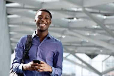 Çanta ve cep telefonu ile Afrikalı-Amerikalı genç adam portresi 