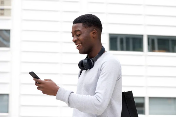 Sida Porträtt Stilig Ung Svart Man Tittar Mobiltelefon Utanför — Stockfoto