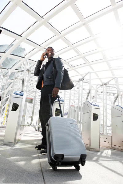 スーツケースと駅で携帯電話で旅行する若い人のフルの長さの肖像画 — ストック写真