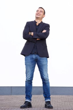 Silah ile beyaz duvara gülüyor 30s mutlu bir adam portresi tam vücut geçti